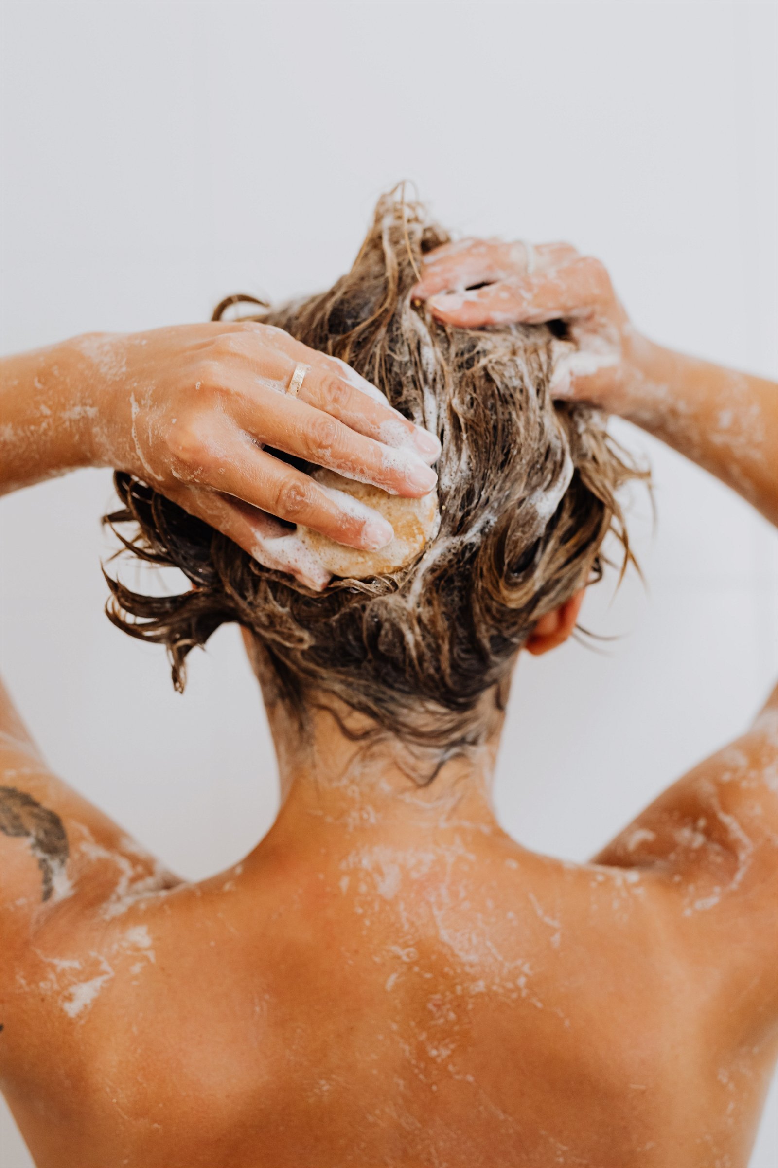 mujer lavandose el cabello