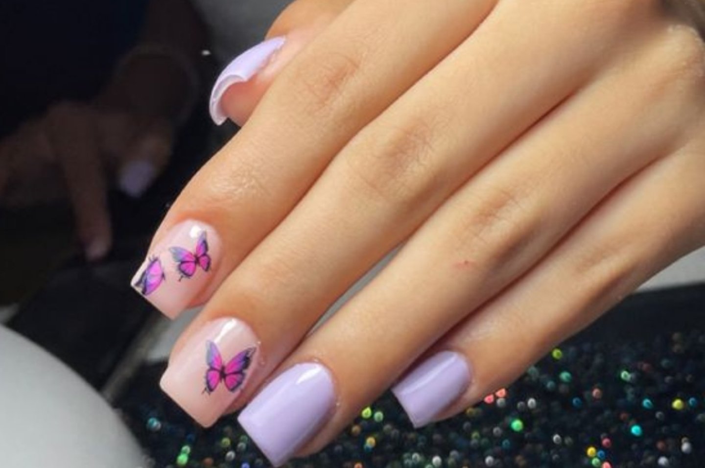 Manicura lila con mariposas