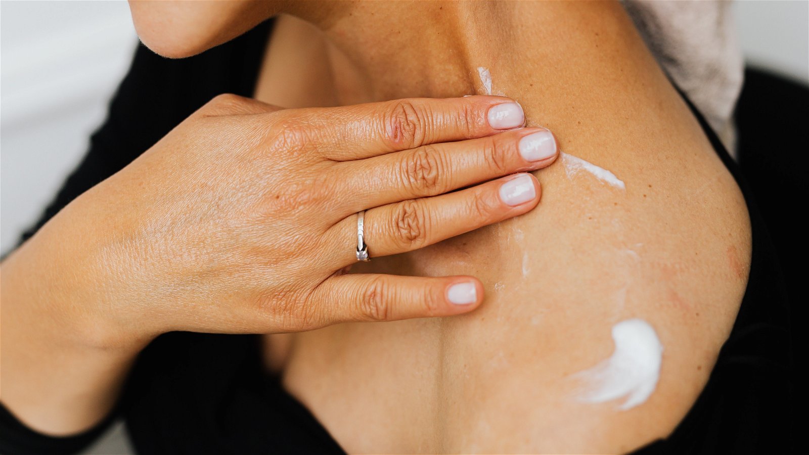 Mujer aplicando crema solar en el cuerpo