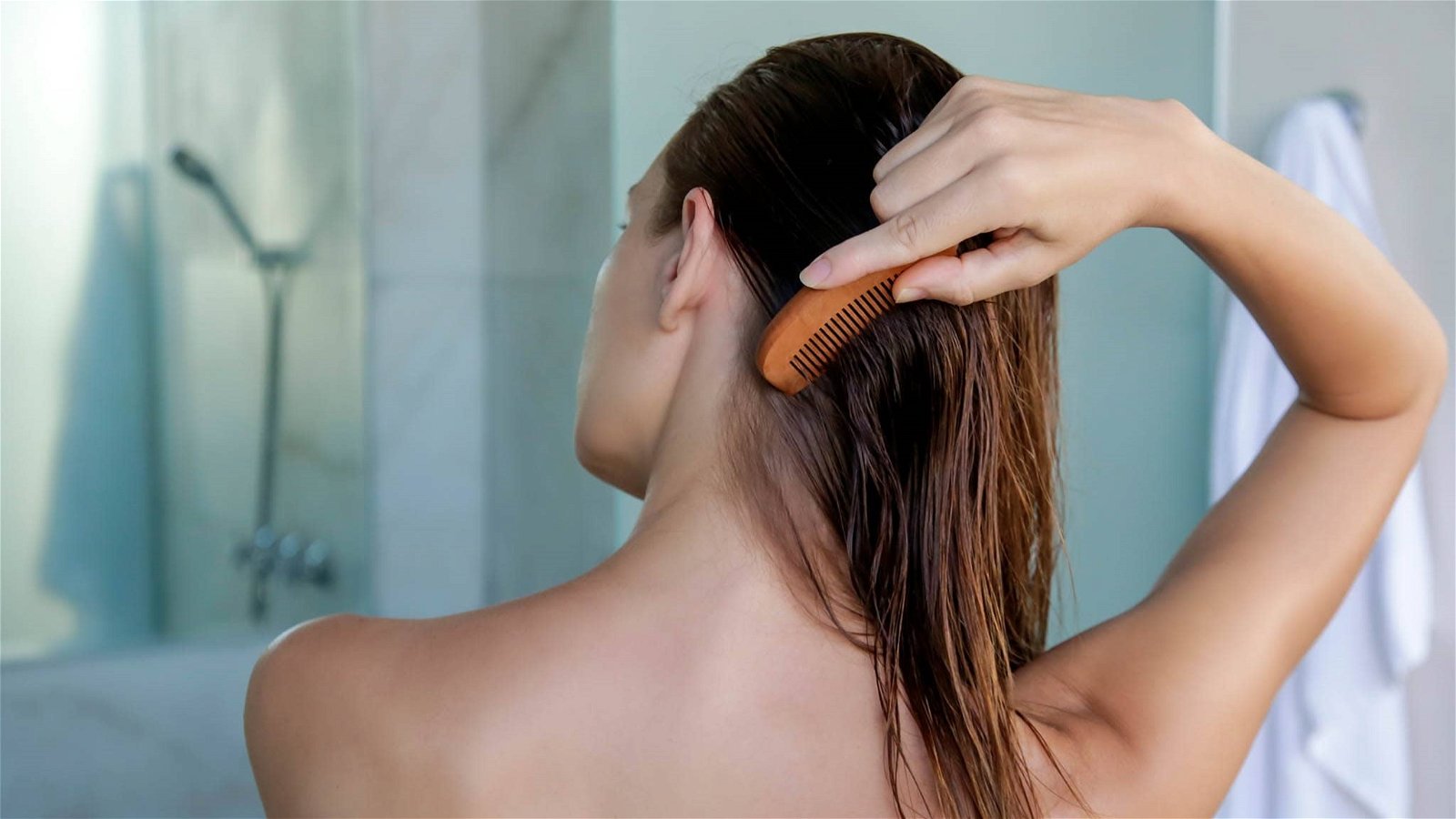 Mujer peinando su cabello después de aplicar aceite de almendras