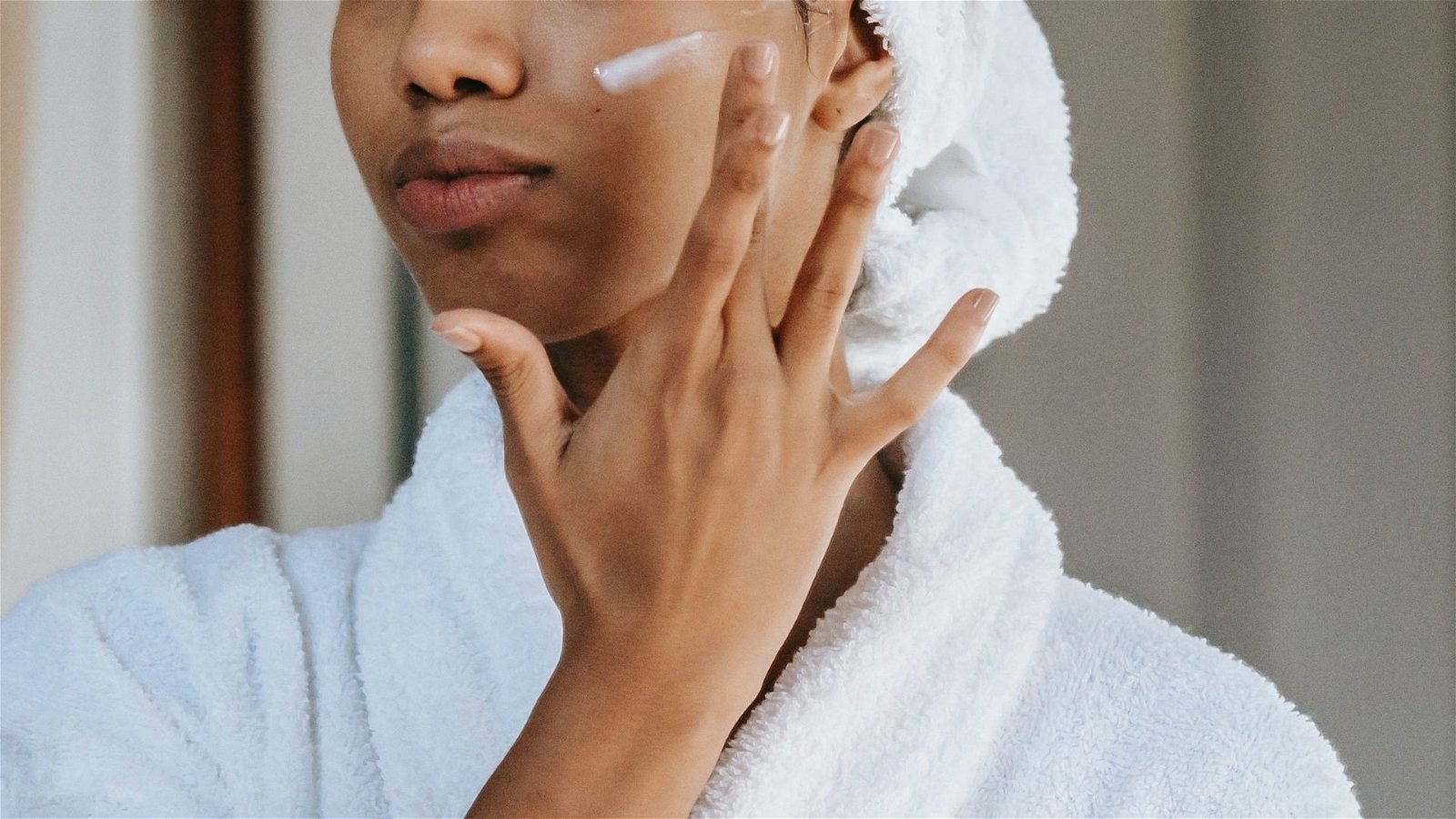 Mujer aplicando crema en su rostro