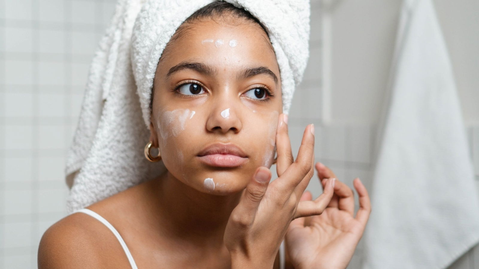 Mujer aplicanco crema en su rostro