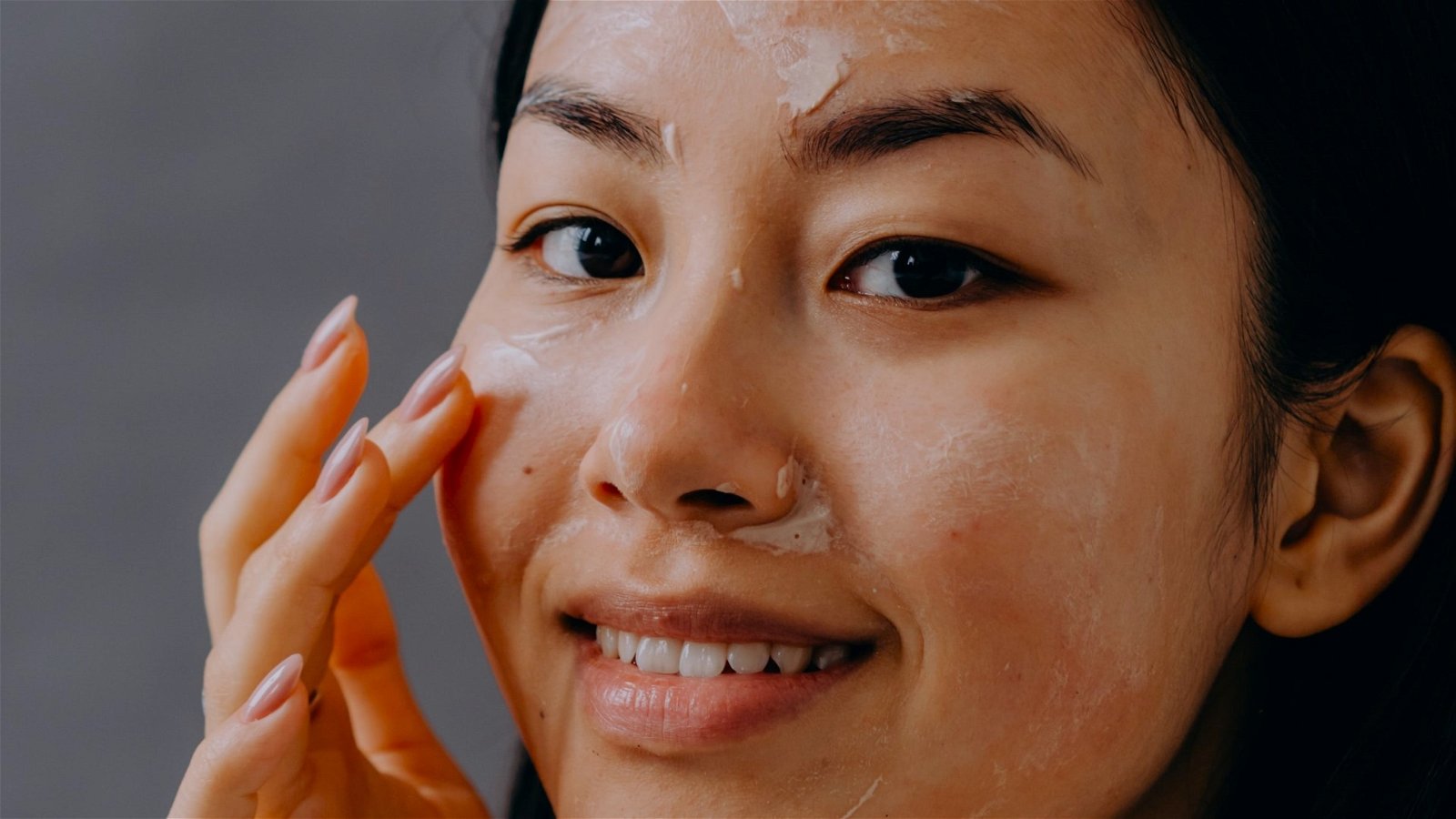 Mujer aplicando crema en su rostro 2