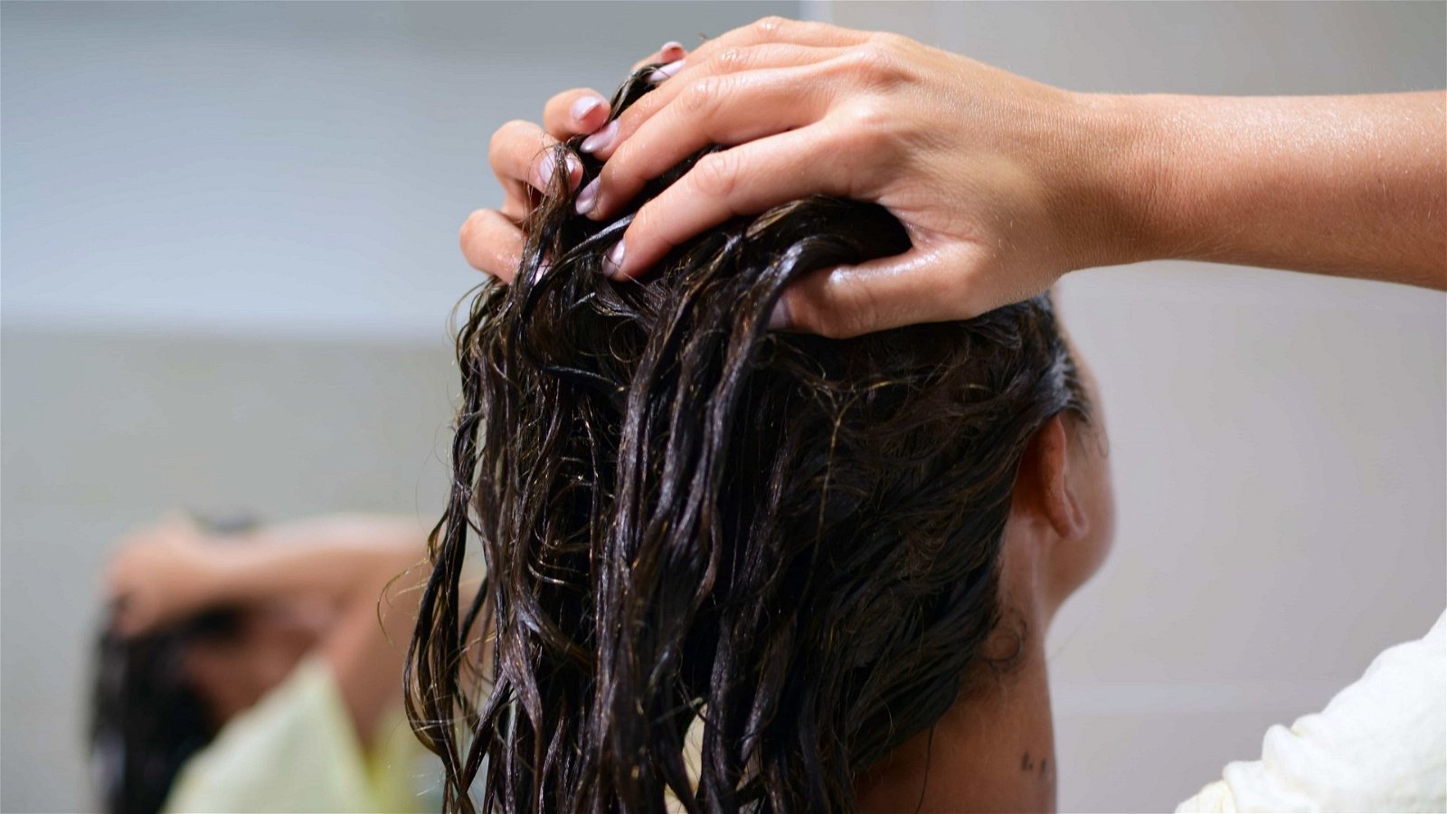 Mujer lavando su pelo con vinagre de sidra de manzana