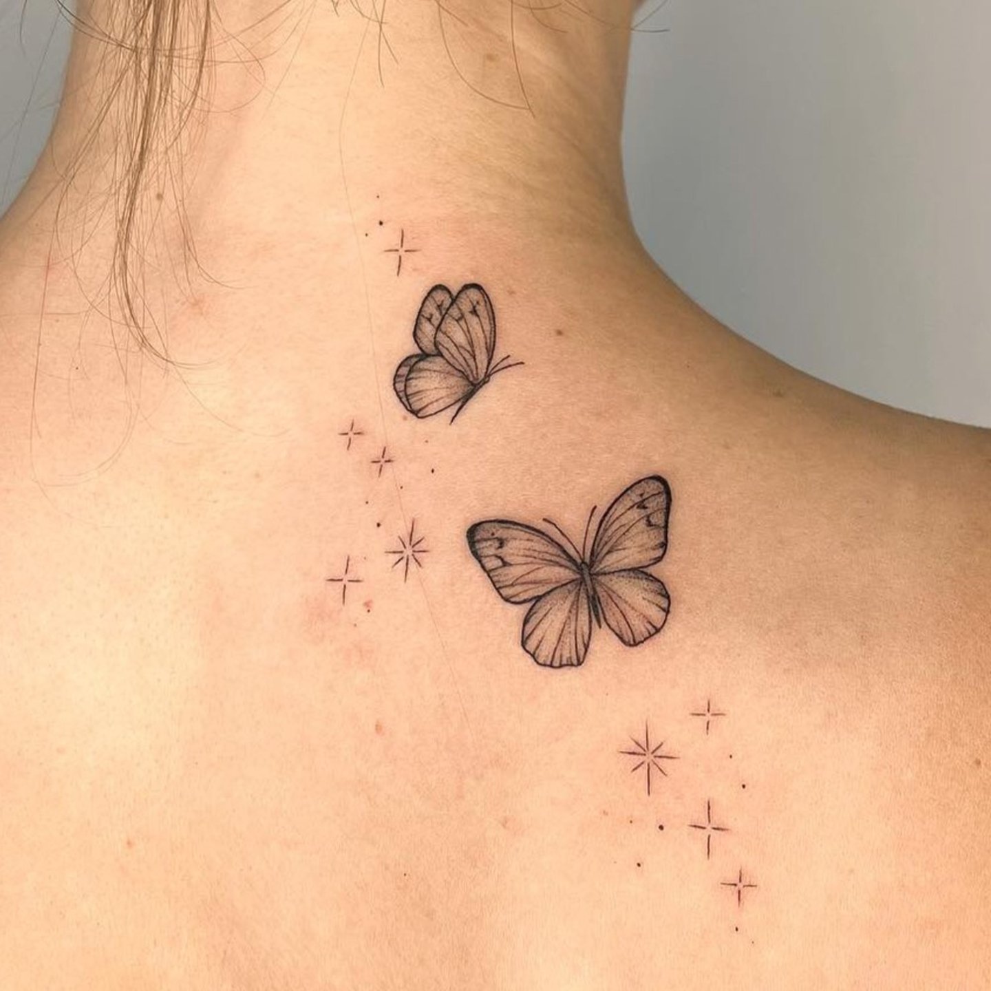 Tatuaje de mariposa y estrellas