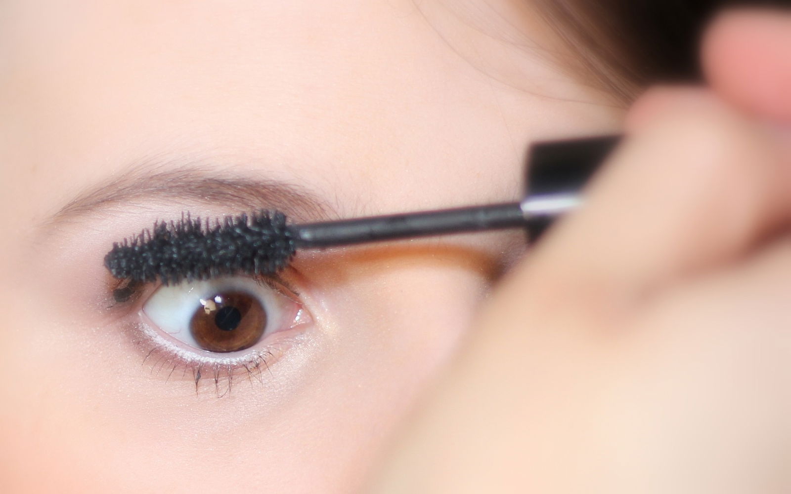 mujer usando mascara de pestañas