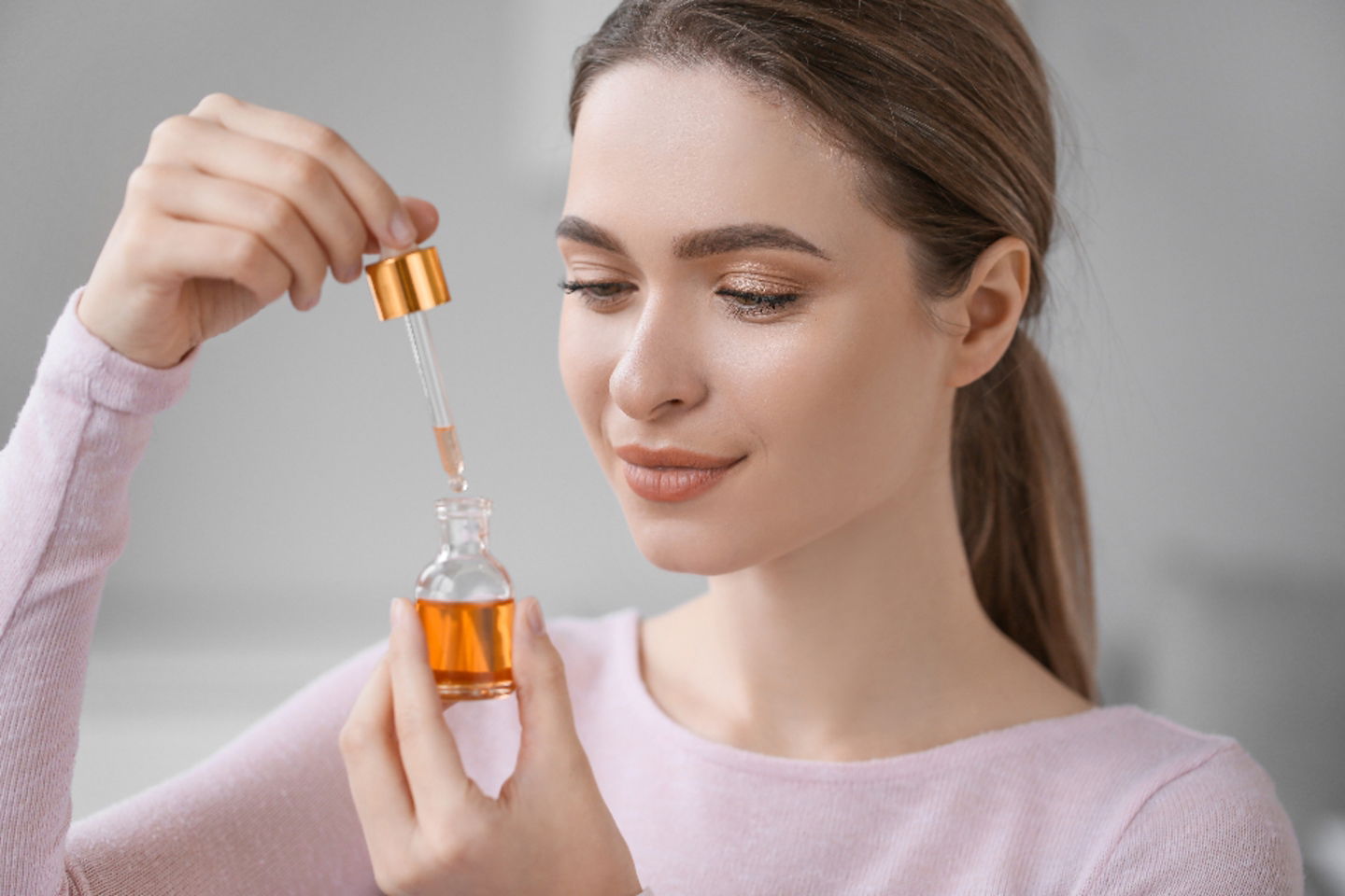 mujer destapando un serum facial