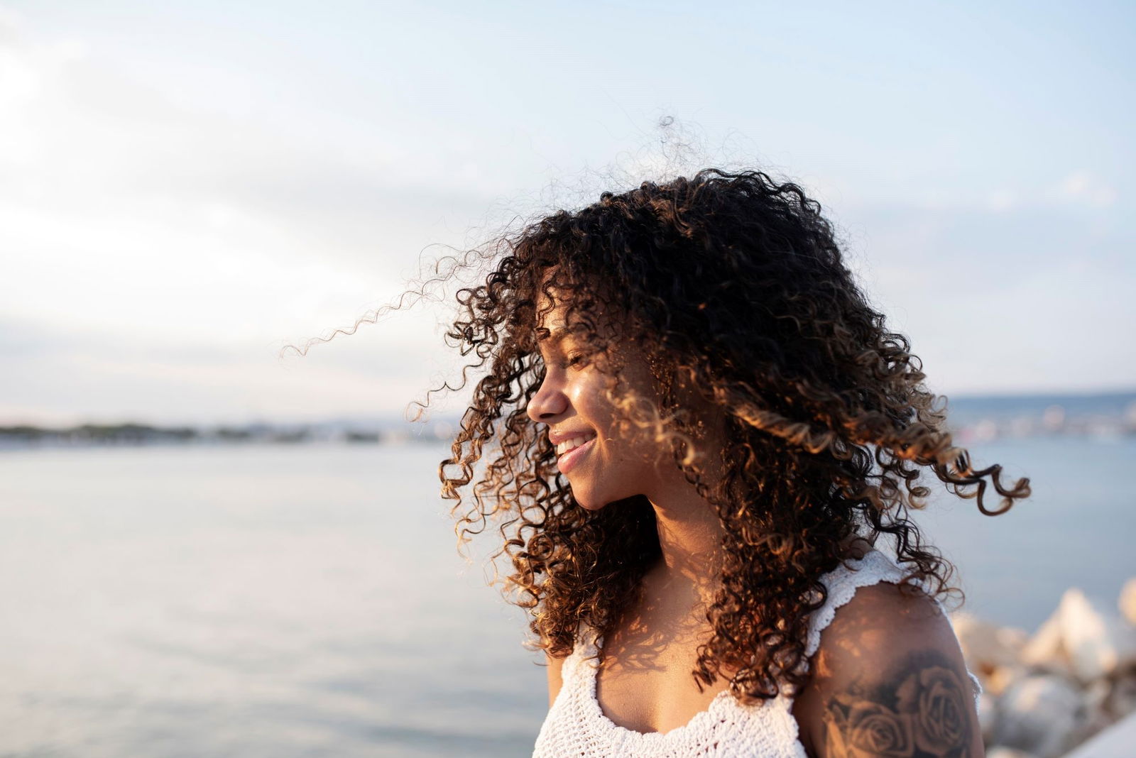 Mujer pelo rizado playa